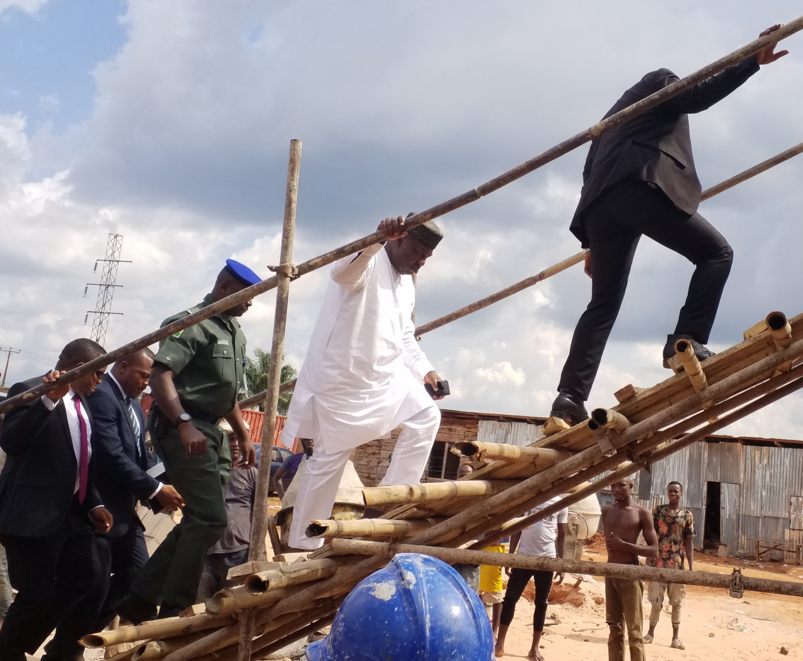 Enugu State Governor, Rt. Hon. Ifeanyi Ugwuanyi (in white) climbing a makeshift staircase to inspect the ongoing construction of the State Secretariat annex at Ede-Oballa, Nsukka Local Government Area, yesterday. 